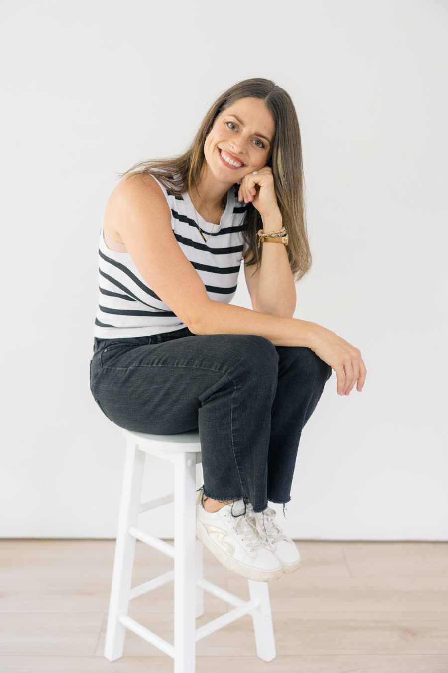 Julianne Daniel seated on a stool, smiling