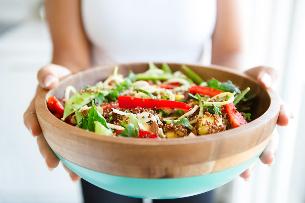 Fresh salad bowl held in hands
